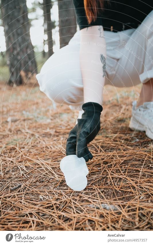 Aktivistin junge Frau Abholung Müll mit Müllzange close up.Forest Hintergrund, mountain.Generation z, Glück Lehren und Lernen Sammeln von Müll und recyceln.Awareness, erneuerbare Quellen