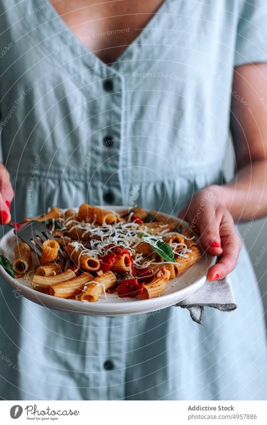 Anonyme Frau mit Pasta Alla Puttanesca-Gericht Beteiligung Spätzle puttanesca Makkaroni Speise Penne Rigate Mittagessen Hände anonym unkenntlich Abendessen