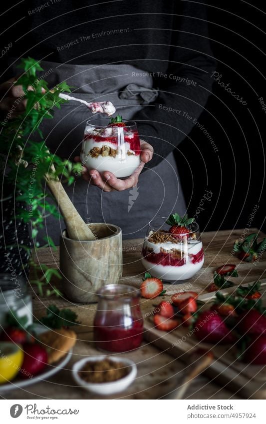 Chefkoch beim Kochen eines leckeren Desserts mit frischen Beeren in einer dunklen Küche Erdbeeren Käse Lebensmittel Hand Vitamin süß Person Gesundheit Scheibe