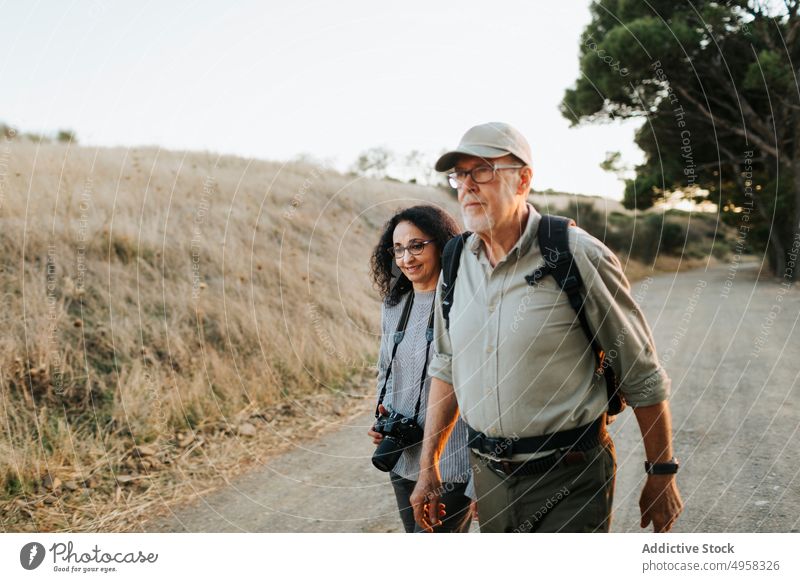 Glückliches älteres Paar in friedlicher Landschaft stehend Senior sorgenfrei Feld Umarmen Wiese reif Fotograf heiter Freund Natur Wanderung Fotografie