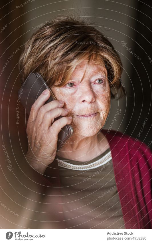 Ältere Frau beim Telefonieren zu Hause sprechen Smartphone heimwärts Anruf in den Ruhestand gehen Hautfalten ruhen Anschluss zuhören älter reif Mobile Senior