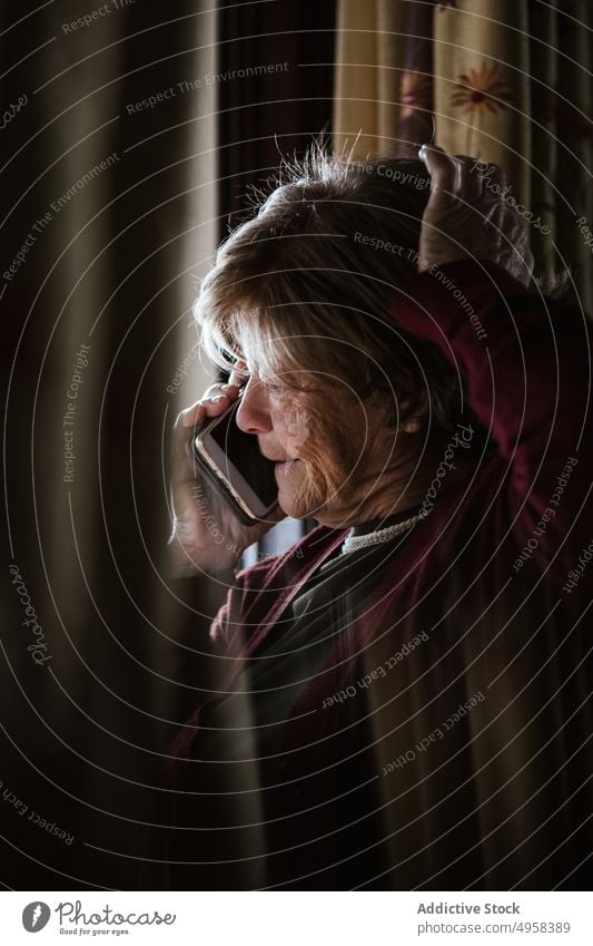 Ältere Frau beim Telefonieren zu Hause sprechen Smartphone heimwärts Anruf in den Ruhestand gehen Hautfalten ruhen Anschluss zuhören älter reif Mobile Senior