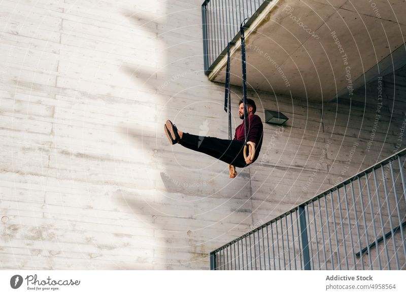 Sportlicher Mann balanciert auf Gymnastikringen Sportler Ausgewogenheit gymnastisch Ring Großstadt sportlich jung aktiv Training Konstruktion Körper Lifestyle