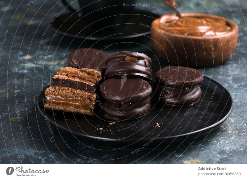 Schokoladen-Alfajores und Dulce de Leche bei heißer Schokolade alfajor dulce de leche Dessert süß lecker geschmackvoll Teller Lebensmittel appetitlich Portion