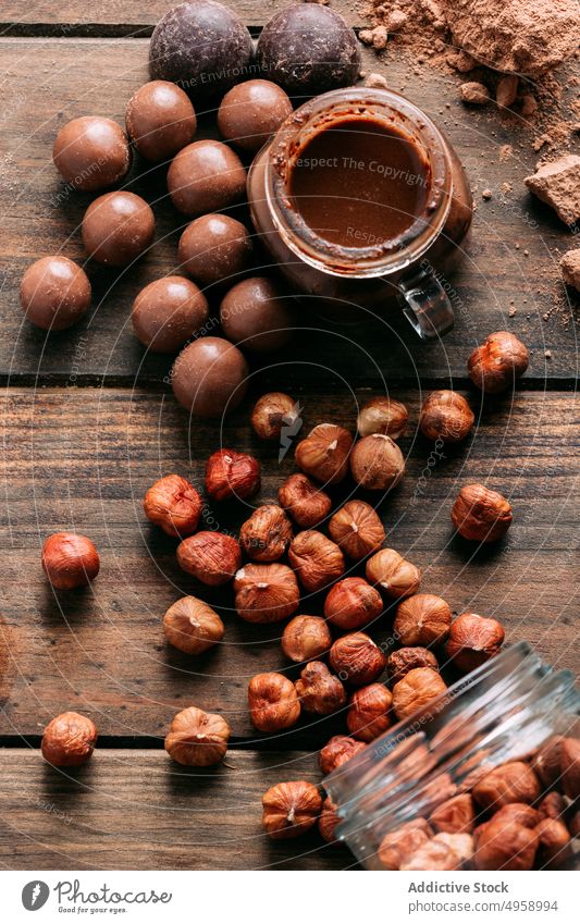 Leckere verschiedene Schokoladenbonbons und Nüsse auf einem Tisch mit Zutaten süß Dessert handgefertigt Erdnuss Butter Zimt Walnussholz Haselnuss lecker