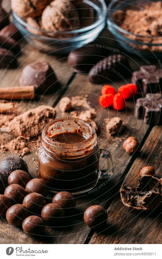 Leckere verschiedene Schokoladenbonbons und Nüsse auf einem Tisch mit Zutaten süß Dessert handgefertigt Erdnuss Butter Zimt Walnussholz Haselnuss lecker