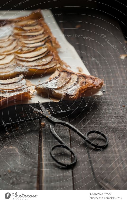 Servierter Apfelkuchen auf dem Kühlgestell Pasteten rustikal Frangipane Mandel Bäckerei Konditorei Aroma gold Schere Ablage Pergament kulinarisch Dessert