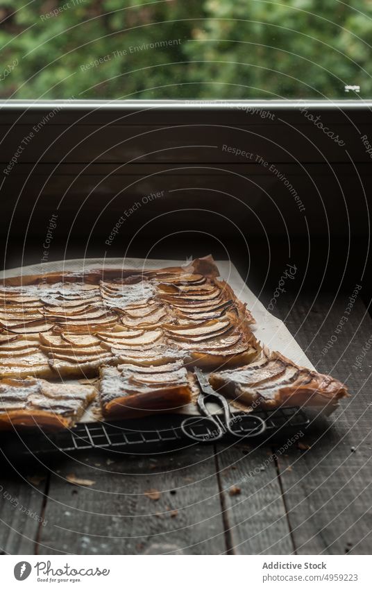 Apfelkuchen in Stücken auf Pergamentpapier serviert Pasteten frisch Holz rustikal Fenster Frangipane selbstgemacht Tageslicht braun Konditorei organisch warm