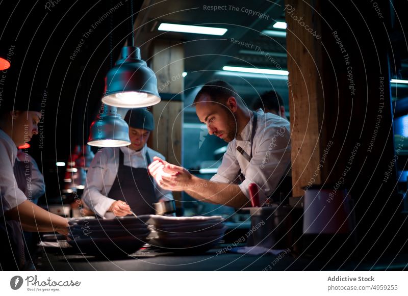 Köche servieren Essen in der Restaurantküche kocht Servieren Mahlzeit Lebensmittel Küche Speise Küchenchef Mann professionell Teller Uniform männlich Menschen