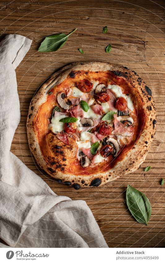 Leckere Pizza mit Pilzen und Kräutern auf dem Tisch lecker geschmackvoll Lebensmittel Tomate Basilikum Küche frisch Mittagessen kulinarisch Bestandteil