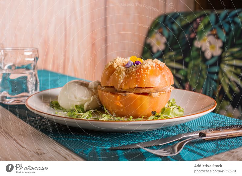 Gefüllte Tomate auf einem Teller im Cafe Zeug Speise dienen Gemüse appetitlich Lebensmittel Restaurant Mahlzeit lecker geschmackvoll rosa hölzern Tisch grün