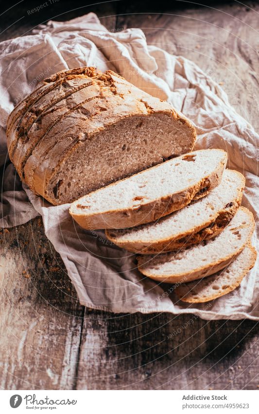 Geschnittenes Vollkornbrot auf dem Holztisch verstreut Brot Scheibe frisch Brotlaib gebacken Ernährung rustikal Lebensmittel Küche Bäckerei selbstgemacht