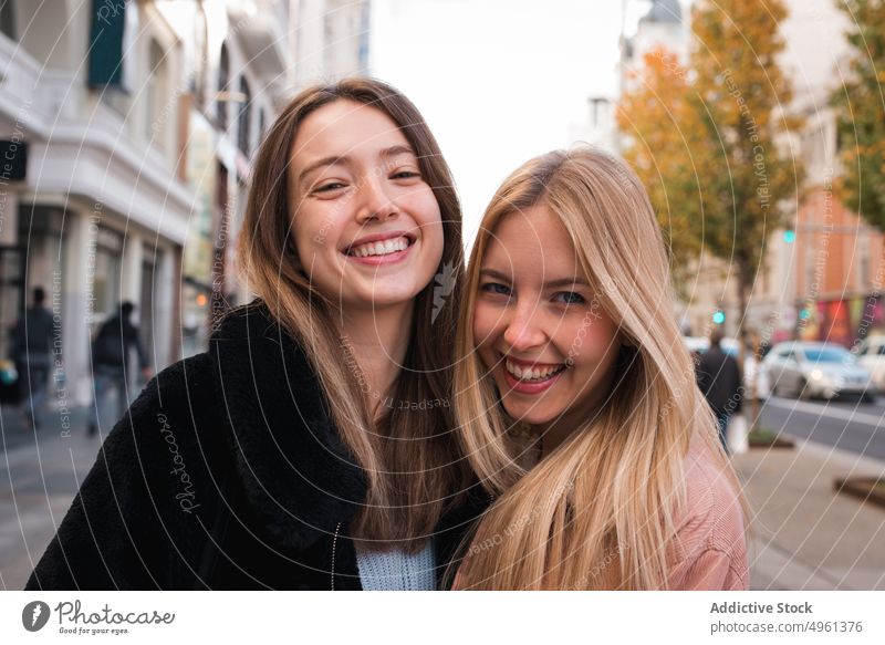 Lächelnde Freundinnen schauen in der Stadt in die Kamera Frauen bester Freund Großstadt charmant positiv Straße schlendern Wochenende Madrid Spanien jung Glück