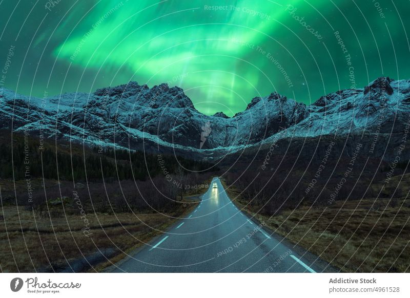 Auto auf der Straße unter grünen Nordlichtern bei Nacht PKW Berge u. Gebirge Winter Licht nördlich polar Landschaft Aurora Himmel glänzend Norwegen