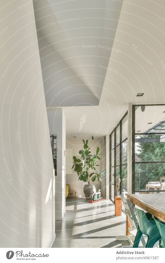 Modernes Haus mit Möbeln neben einem Fenster Innenbereich modern beleuchtet heimwärts Wohnzimmer Esszimmer Wand Textfreiraum Tisch Stuhl weiß Zimmerdecke werfen