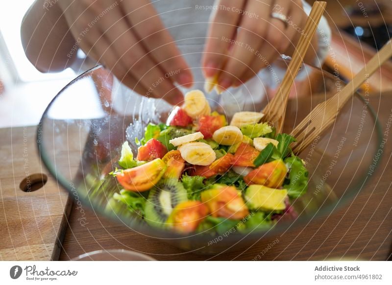 Hündin mit Banane im Salat Frau hinzufügen Salatbeilage Schalen & Schüsseln Koch Küche heimwärts gesunde Ernährung Mittagessen vorbereiten Frucht organisch reif