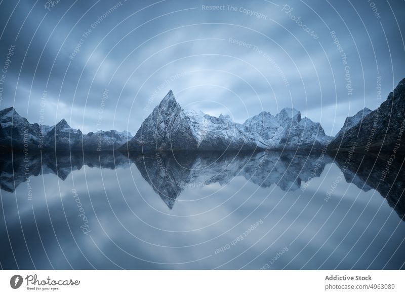 Felsiger Gebirgskamm und wogendes Meer vor düsterem Himmel in Norwegen Berge u. Gebirge MEER Landschaft Natur Klippe Schnee Hochland Ambitus bedeckt wolkig