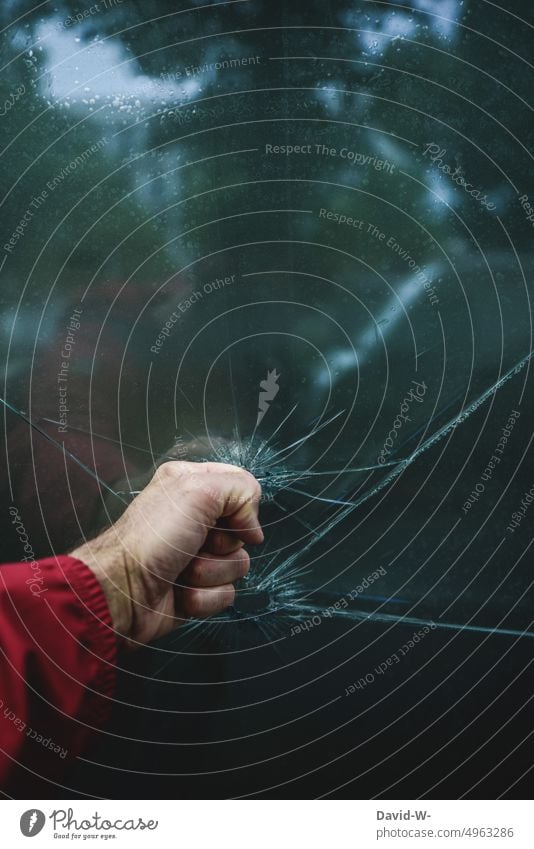 randalieren - Mann schlägt mir der Faust eine Scheibe ein Vandalismus Randalismus zerstören Wut Zerstörung Fensterscheibe Glas zerbrochen Zerbrochenes Fenster