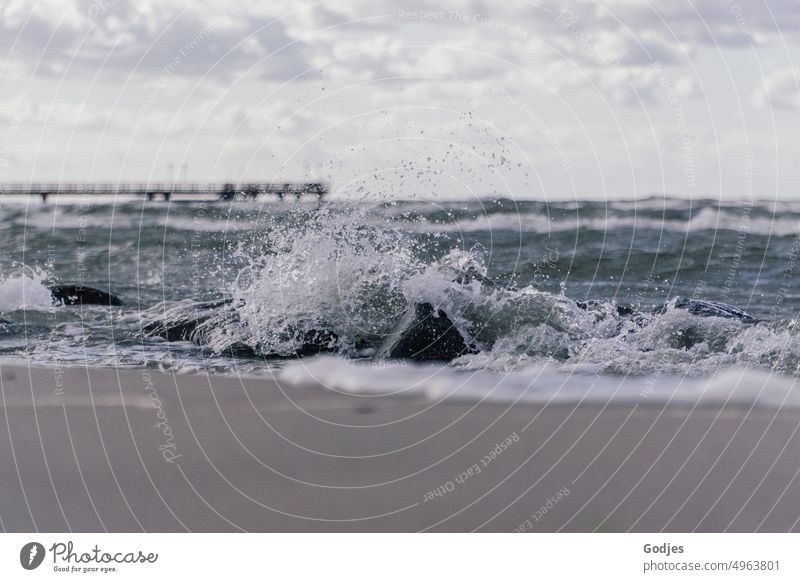 Welle bricht auf Steinen am Strand Gischt Ostsee Himmel Wolken stürmisch Steg Meer Wasser Küste Wellen Natur Sturm Landschaft blau Farbfoto