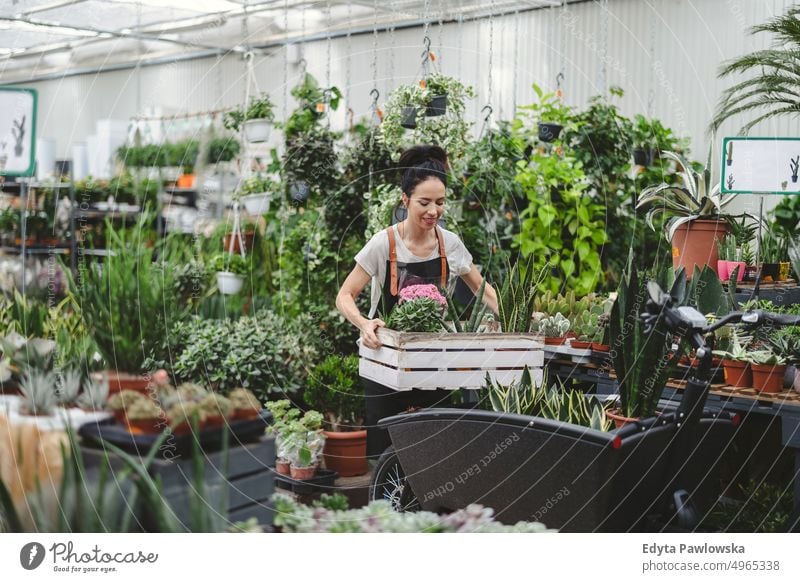 Frau arbeitet in einem Gartencenter Gärtnerei Lächeln Positivität Natur Gartenarbeit kultivieren Wachstum Hobby Frische Pflanze wachsend Flora grün Blumen