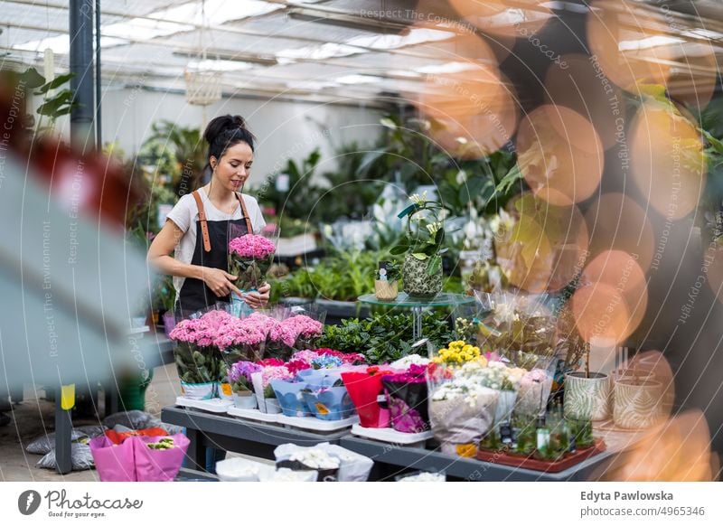 Florist im Blumenladen, der sich um die Pflanzen kümmert Gärtnerei Lächeln Positivität Natur Garten Gartenarbeit kultivieren Wachstum Hobby Frische wachsend