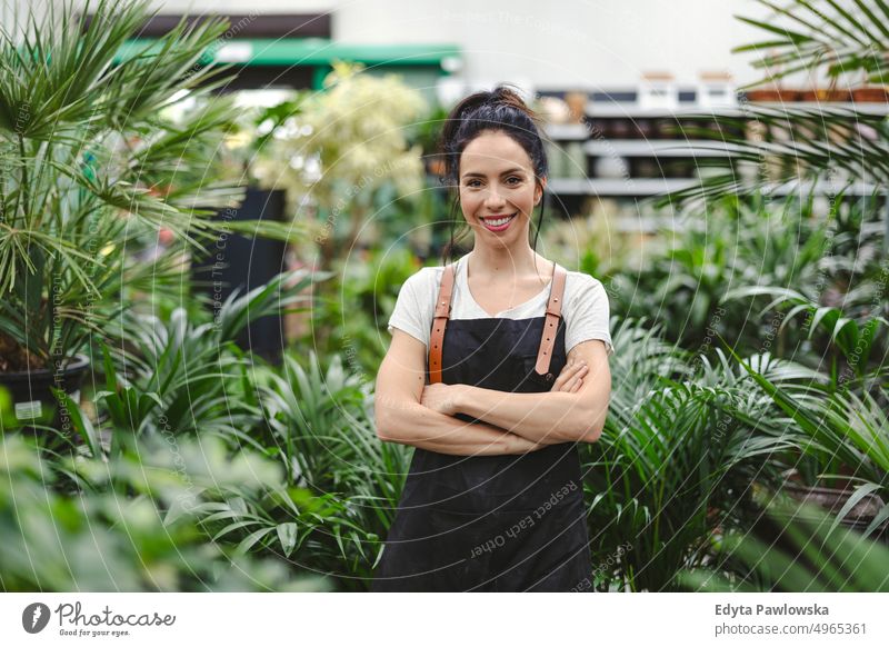 Frau arbeitet in einem Gartencenter Gärtnerei Lächeln Positivität Natur Gartenarbeit kultivieren Wachstum Hobby Frische Pflanze wachsend Flora grün Blumen