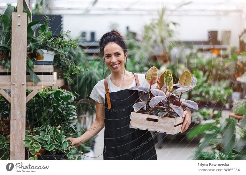 Frau arbeitet in einem Gartencenter Gärtnerei Lächeln Positivität Natur Gartenarbeit kultivieren Wachstum Hobby Frische Pflanze wachsend Flora grün Blumen