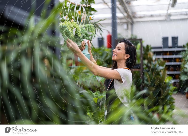 Florist im Blumenladen, der sich um die Pflanzen kümmert Gärtnerei Lächeln Positivität Natur Garten Gartenarbeit kultivieren Wachstum Hobby Frische wachsend