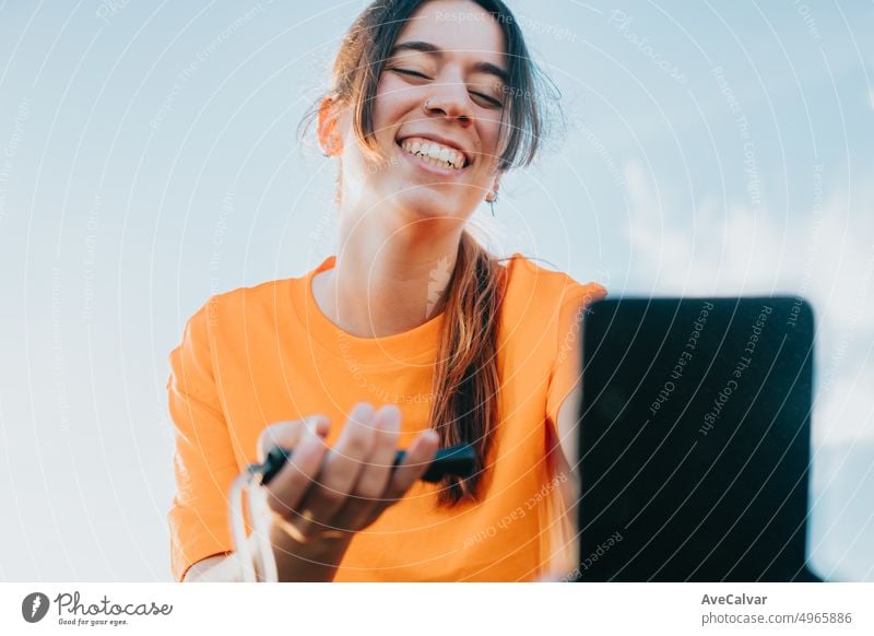 Junge Frau hält einen springenden Kamm und zeigt ihn den Anhängern im Livestream, gesunder Influencer. Sport und gesunder Lebensstil in sozialen Netzwerken. Urbaner Ort, Training in der Stadt