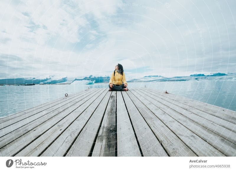 Weibliche Reisende Ruhe auf einem Tranquil Pier in der Nähe von Jokursarlon Gletscher, Hintergründe Landschaft scene.Freedom Freiheit und scape Konzept.Natural wilden Blick.Adventure Urlaub gesunden Lebensstil Rucksacktourismus.