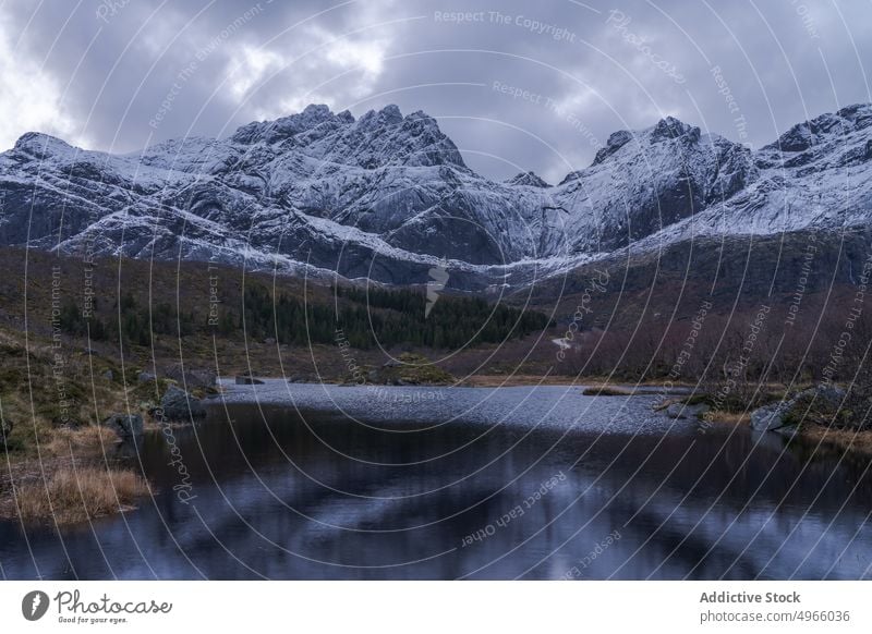 Aussicht auf verschneite Berge und See bei bedecktem Himmel Berge u. Gebirge Winter Kamm Norwegen Lofoten Inseln Landschaft Schnee majestätisch Hochland