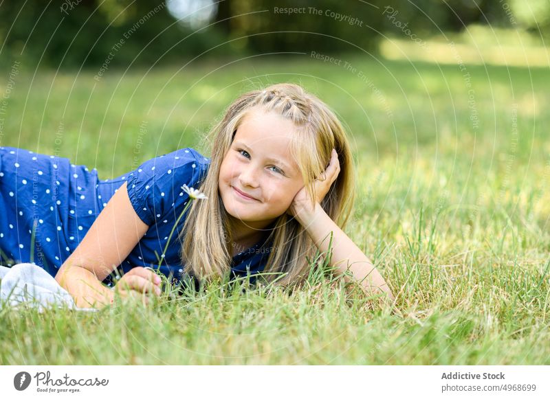 Glückliches Mädchen im Gras liegend Feld ruhen Lächeln Blume Gänseblümchen Wochenende Sommer sich auf die Hand lehnen blond Rasen Wiese Blütezeit froh Flora