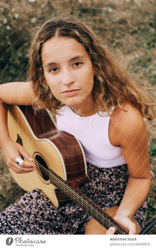 Frau spielt Gitarre in einem Feld mit trockener Vegetation Musik Spielen romantisch jung spielen Instrument heiter Musical Spaß Urlaub Mode Feiertag lässig