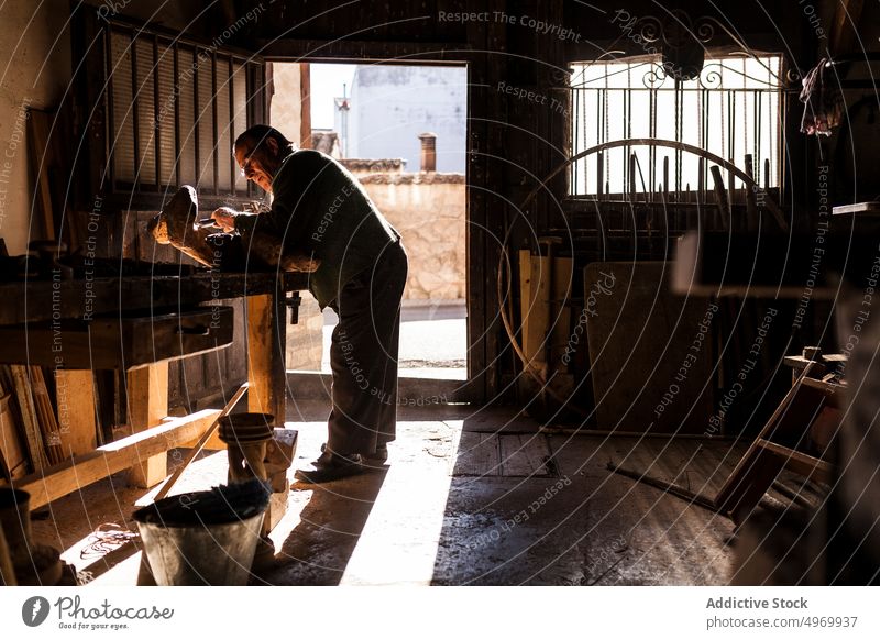 Älterer Schreiner bei der Arbeit mit Holz Zimmerer Beitel Hammer Werkstatt älter Hände knittern Gerät Werkzeug Industrie Handwerk Tischlerin männlich Senior