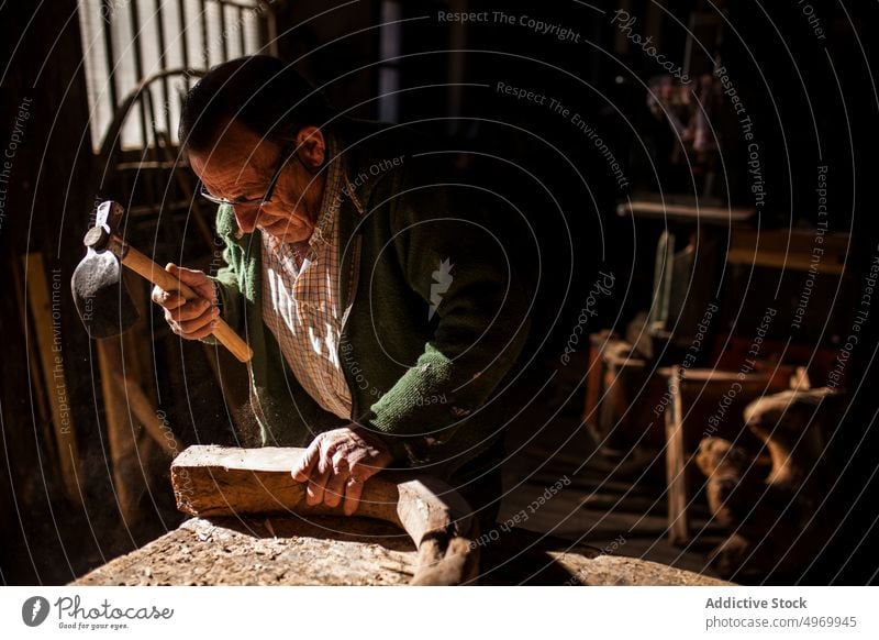 Älterer Mann bei der Arbeit mit Holz Zimmerer Werkzeug Werkstatt älter Hammer Gerät Industrie Handwerk Tischlerin männlich Senior reif manuell Job Hobby