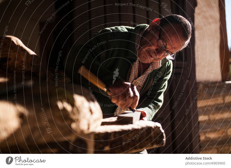 Älterer Schreiner bei der Arbeit mit Holz Zimmerer Beitel Hammer Werkstatt älter Hände knittern Gerät Werkzeug Industrie Handwerk Tischlerin männlich Senior