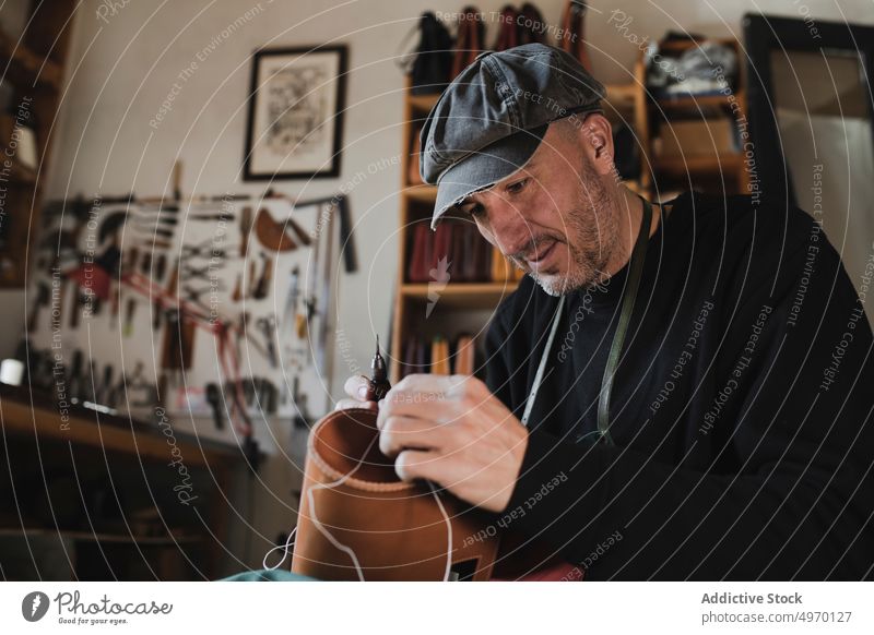 Mann näht Textil im Atelier Schneider Nähen Nadel Werkstatt Leder dickey Arbeitsplatz Mode Bekleidung Damenschneiderin Design Hut Handwerk Gewebe Industrie