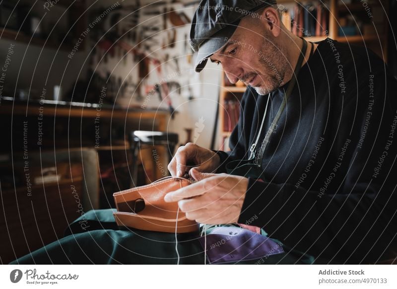 Mann näht Textil im Atelier Schneider Nähen Nadel Werkstatt Leder dickey Arbeitsplatz Mode Bekleidung Damenschneiderin Design Hut Handwerk Gewebe Industrie