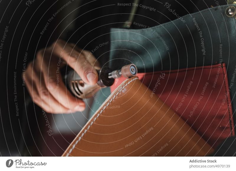 Mann poliert Leder im Atelier Schneider Polieren Werkstatt Textil Schneiden Nähmaschine dickey Presse Arbeitsplatz Mode Bekleidung Damenschneiderin Design