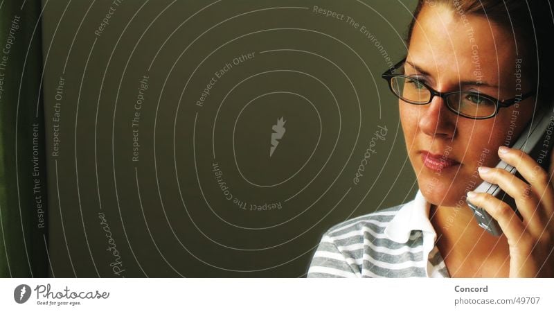 wie geht`s Frau brünett Brille Handy Seite Silhouette sprechen Am Rand Wachsamkeit Konzentration Denken Innenaufnahme Porträt Vor dunklem Hintergrund Raum