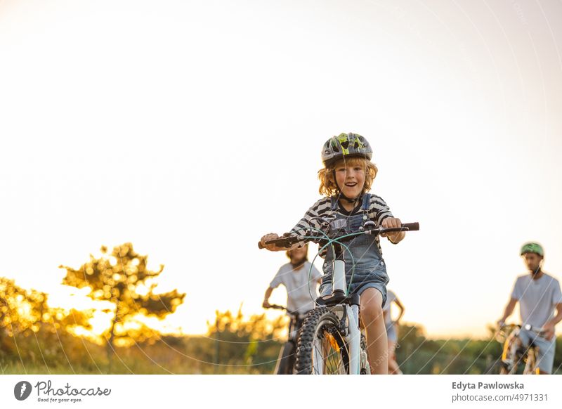 Glückliche Familie beim gemeinsamen Radfahren auf dem Lande Tag Gesunder Lebensstil aktiver Lebensstil im Freien Spaß Freude Fahrrad Fahrradfahren Aktivität