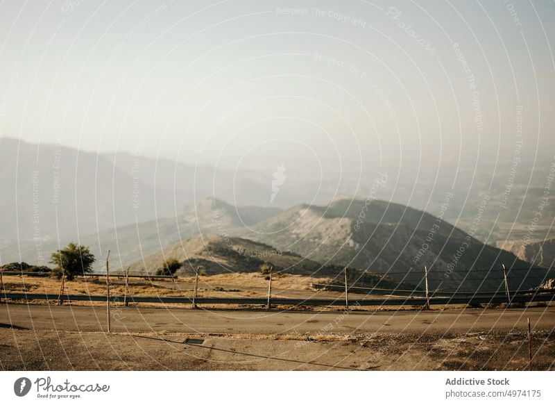 Leere Straße gegen neblige Berge am Horizont Berge u. Gebirge Hochland Nebel Abenteuer Kamm reisen Ambitus Zaun Ausflug Hügel Umwelt Landschaft friedlich