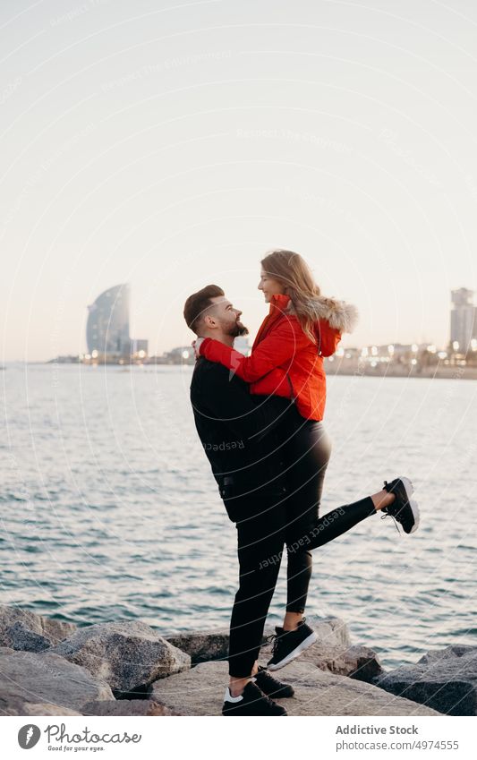 Junges romantisches Paar am Strand Liebe Barcelona Beteiligung Hände Lächeln Datierung Winter jung Typ Mädchen Menschen Freunde Lachen Glück Mann Frau kalt