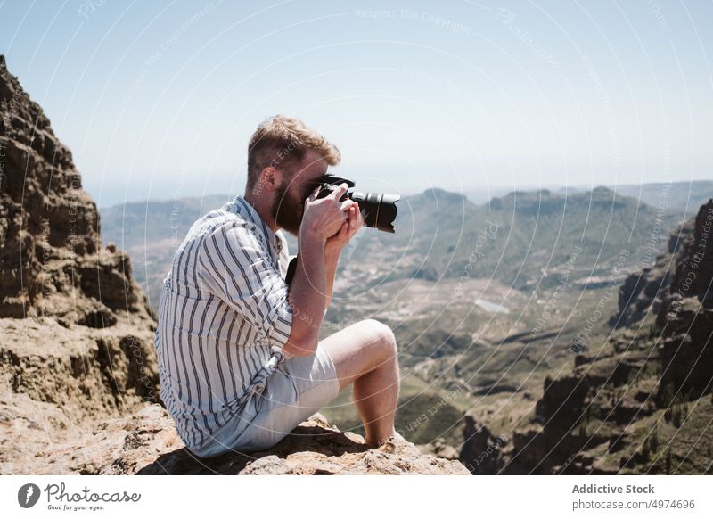 Fotograf beim Fotografieren in einer Berglandschaft Mann Berge u. Gebirge Person Landschaft Natur im Freien reisen Fotokamera Abenteuer Himmel Tourismus