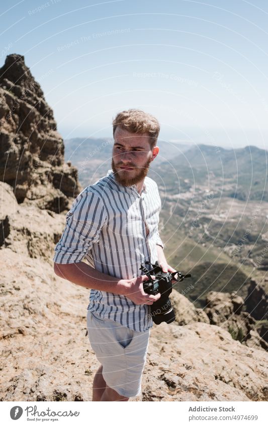 Fotograf beim Fotografieren in einer Berglandschaft Mann Berge u. Gebirge Person Landschaft Natur im Freien reisen Fotokamera Abenteuer Himmel Tourismus