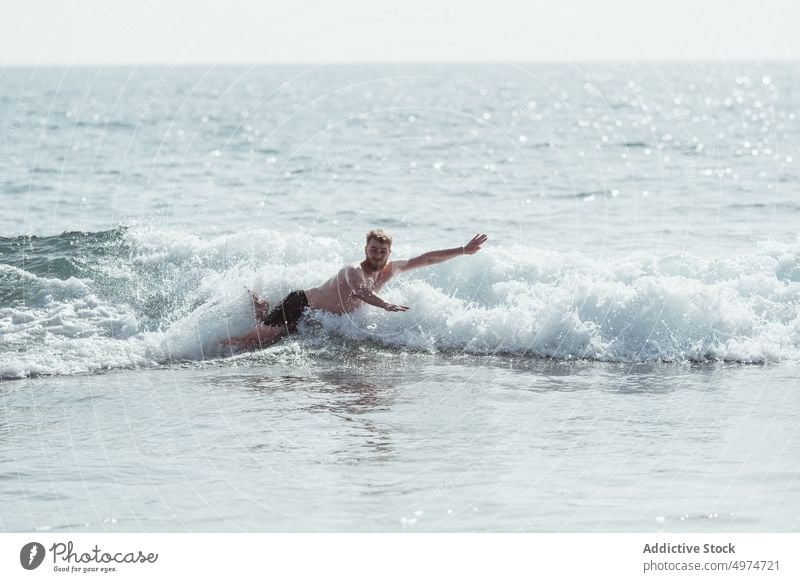 Junger Mann macht einen Bauchklatscher am Strand Flop Wasser Bewegung Freiheit blau Spaß jung Aktivität Aktion schwimmen Sinkflug Aus Person Sommer natürlich