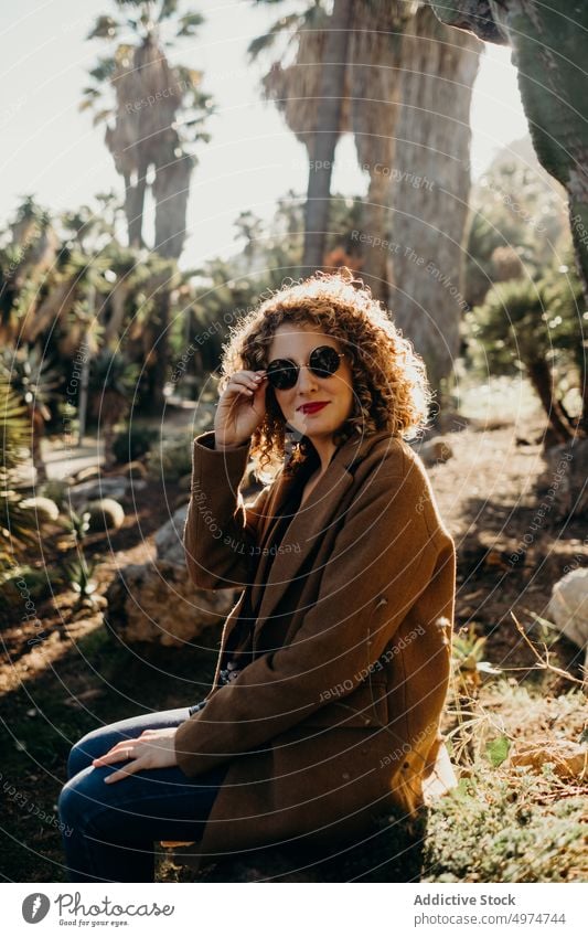 Porträt einer schönen lockigen blonden Frau mit einer schwarzen Sonnenbrille Mode Model fallen Accessoire Bekleidung heiter Mantel selbstbewusst niedlich