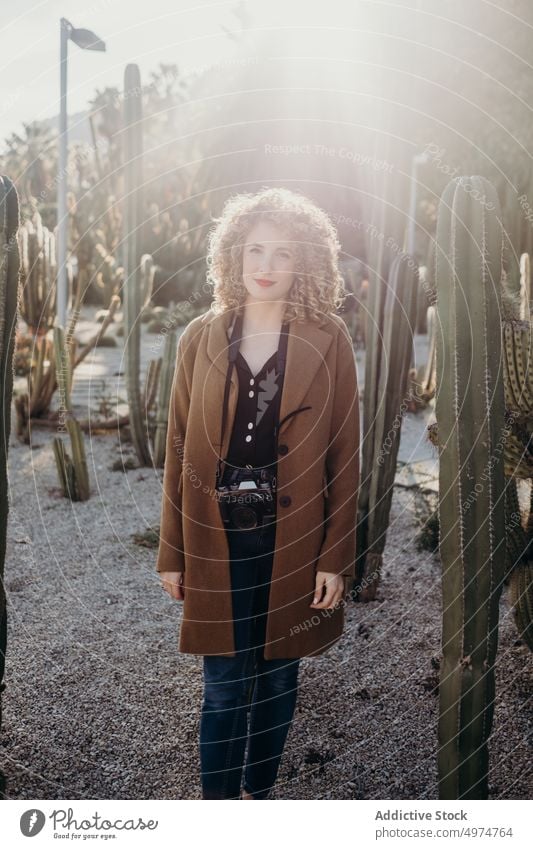 Porträt einer schönen, lockigen, blonden Frau mit einer Retro-Kamera Model im Freien Winter Gesicht Accessoire Bekleidung Fotokamera Mantel selbstbewusst