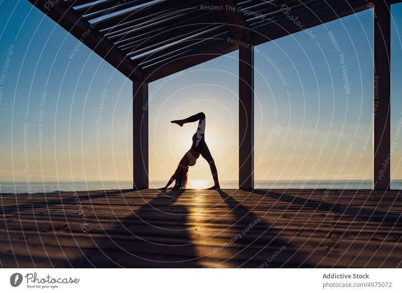 Flexible Frau macht Yoga am Strand Pose Asana Sonnenaufgang Seeküste Dehnung üben Konzentration Harmonie Gesundheit Gleichgewicht sich[Akk] entspannen