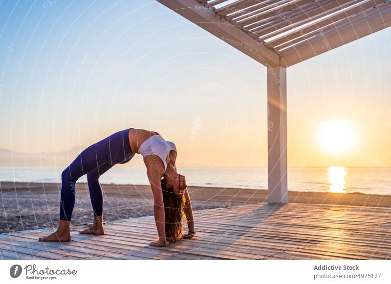 Flexible Frau macht Yoga am Strand Pose Asana Sonnenaufgang Seeküste Dehnung üben Konzentration Harmonie Gesundheit Gleichgewicht sich[Akk] entspannen